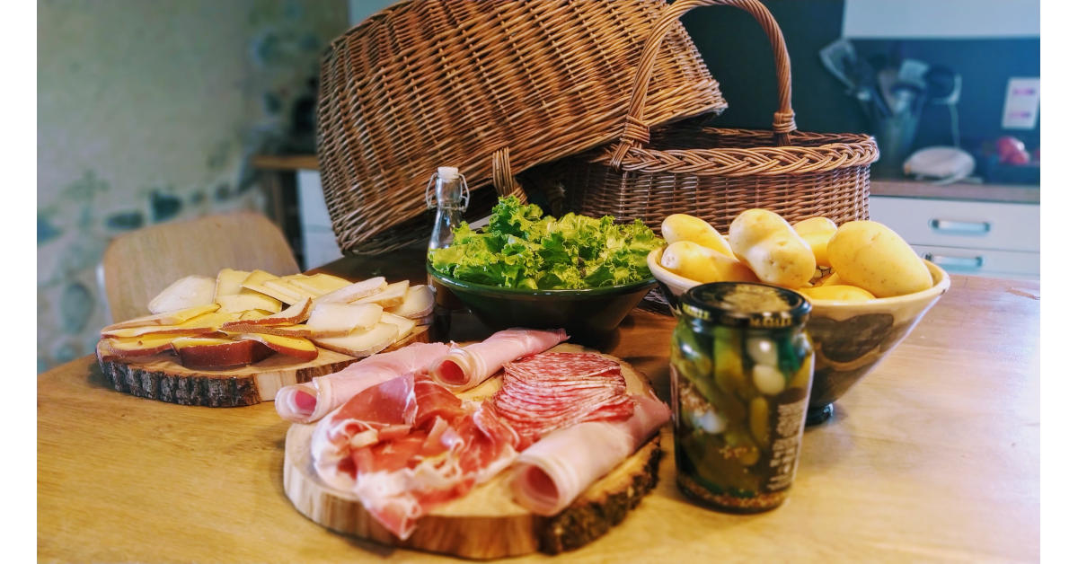 Un plateau de charcuterie, des cornichons, des pommes de terre, de la salade, le tout pour accompagner un bon repas savoyard : raclette ou fondue.