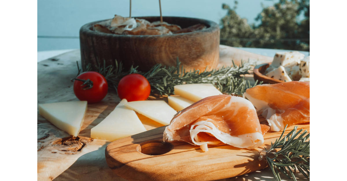 Formage et charcuterie de Savoie sont élégamment présentés sur une planche en bois.